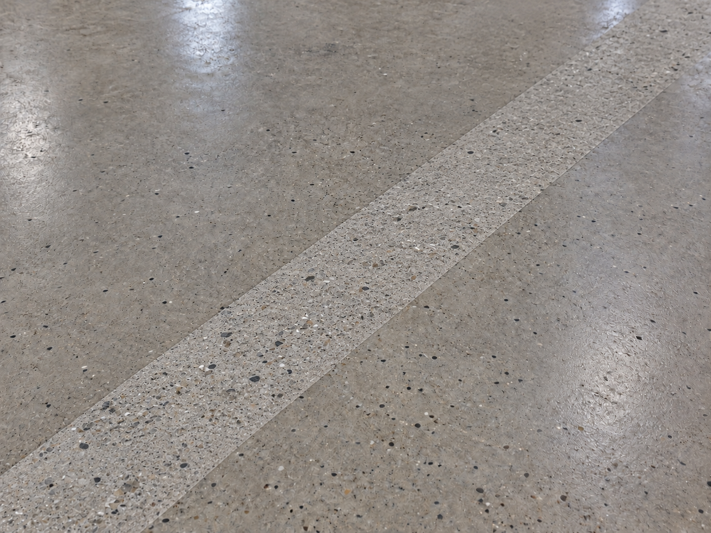 Çevresindeki düzgün betondan matlığı ve dokusuyla ayrılan temiz kuru hazırlanmış beton şeridi